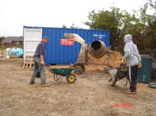 Wheel barrow ready to be filled with mortar mixture from cement mixer